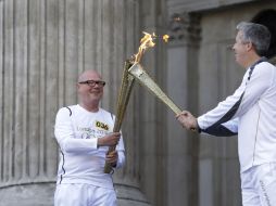 Los relevos de la antorcha estuvieron atentos para trasladar la flama de Londres 2012. AP  /
