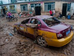 Un taxi se queda atascado en el lodo que produjeron las lluvias, a las afueras de Beijing. AFP  /
