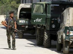 Un rebelde sirio patrulla después de que las fuerzas armadas ocupasen la base militar cercana a Aleppo. EFE  /