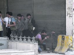 VIGILANCIA. Rebeldes sirios supervisan la zona después de que las fuerzas armadas ocupasen la base militar cercana a Alepo.  EFE  /