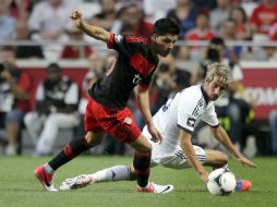 El jugador del Benfica, Enzo Perez (I), se lleva el balón ante el defensor portugués del Real Madrid, Fábio Coentrão. EFE  /