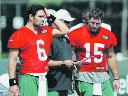 Mark Sánchez (6) y Tim Tebow (15) escuchan las indicaciones del coach de quarterbacks, Matt Cavanaugh. AP  /