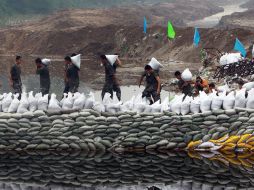 Rescatistas intentan prevenir otros desvíos del caudal. AFP  /