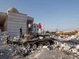Niños sirios juegan en un tanque que fue destruido tras un bombardeo en Aleppo. AFP  /