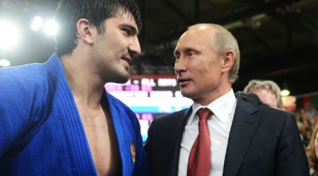 El presidente de Rusia, Valdimir Putin (D), conversa con el judoca Tagir Khaibulaev (I).  /