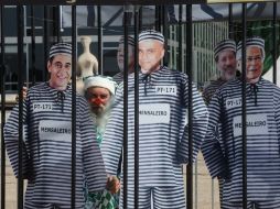 Manifestantes montan una jaula con muñecos que representan al exministro José Dirceu y a miembros del PT, en Brasilia. EFE  /