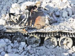 Los estragos de la guerra. Un curioso observa un tanque militar destrozado en el Norte de Alepo. REUTERS  /