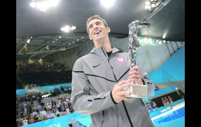 Pilón. Michael Phelps posa junto al trofeo que le otorgó la FINA, por sus logros conseguidos en tres ediciones de Juegos Olímpicos. AP  /