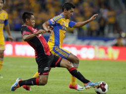 El zaguero rojinegro Gregorio Torres presiona al volante felino, Elías Hernández, durante el duelo disputado anoche en el Jalisco  /