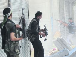 Integrantes del Ejército Sirio Libre disparan sus armas en Alepo, ciudad que el régimen pretende recuperar con bombardeos. EFE  /