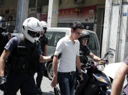 La policía escolta a un inmigrante que vive en Atenas, Grecia, durante la operación 'Xenios Zeus'. EFE  /