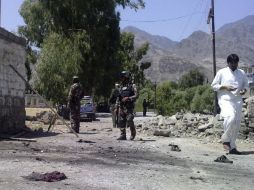Miembros de las fuerzas de seguridad inspeccionan el lugar donde dos suicidas atacaron un convoy de la OTAN. EFE  /