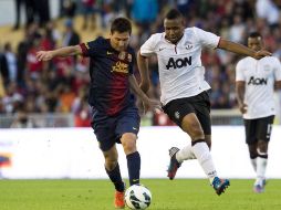Anderson (d) del United intenta disputar el balón al argentino Messi. AFP  /