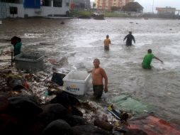 Pobladores de Veracruz rescatan algunas pertenencias de una zona inundada. EFE  /