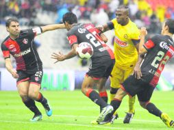 Christian Benítez del América intenta pasar entre dos rojinegros, mientras Cufré vigila. Atlas lamentó la falta de puntería. MEXSPORT  /