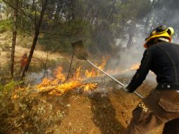 Labores para apagar las llamas en el incendio declarado hoy en el término municipal de Alicante, España. EFE  /