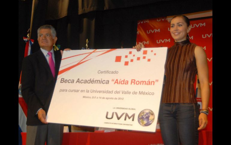El rector de la UVM, Dieter Holtz, entrega la beca educativa a la medallista mexicana Aída Román. NOTIMEX  /