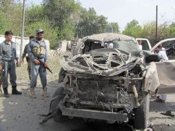 Oficiales de seguridad afganos inspeccionan el lugar donde se ha producido la explosión de una bomba. EFE  /