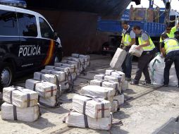 Varios agentes descargan en el puerto de Cádiz la importante cantidad de cocaína hallada a bordo del barco. EFE  /