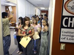 Un coordinador de servicios de educación CHIRLA da instrucciones a un grupo de inmigrantes para entregar su solicitud. EFE  /