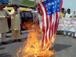 Un hombre quema una bandera de Estados Unidos en protesta contra los ataques a la región tribal. AFP  /