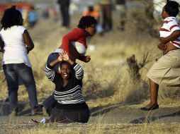 Las esposas de los mineros fallecidos se manifiestan en el lugar en el que sus maridos fueron tiroteados. EFE  /