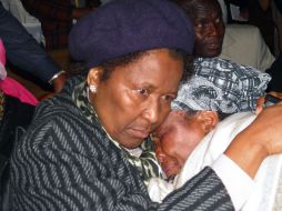 Una mujer consuela a la madre de una de las víctimas durante la celebración religiosa. AFP  /