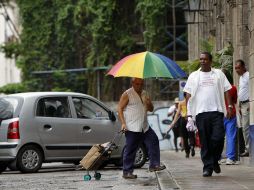 Un señor se protege de la lluvia con una sombrilla en La Habana donde llueve por el paso de ''Issac''. EFE  /
