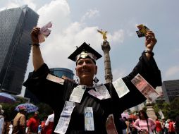 Un manifestante muestra dinero falso en la marcha de hoy, en la Ciudad de México. REUTERS  /