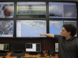 Un técnico señala un mapa con la ubicación del epicentro de un poderoso sismo que afectó a El Salvador durante la madrugada. EFE  /