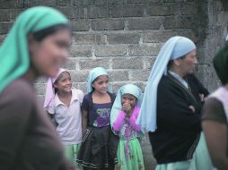 Niñas fieles a la Virgen del Rosario ríen mientras observan la protesta que realizan pobladores que demandan educación secular. AP  /