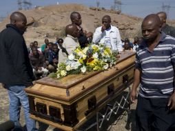 Los mineros de la huelga sostienen el ataúd de Mpuzeni Ngxande, uno de los asesinados durante la manifestación. REUTERS  /