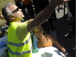 Un manifestante y un oficial de polícia atienden una emergencia médica durante la protesta. AFP  /