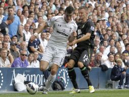Garreth Bale se disputa la pelota con Anthony Pilkington del Norwich City. AP  /