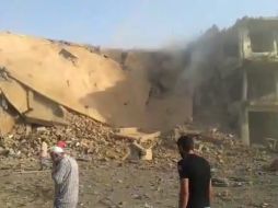 Imagen de una grabación distribuida por Shaam News Network (SNN) que muestra a sirios ante un edificio en ruinas tras ser atacado. EFE  /