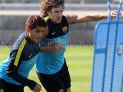 Dos Santos disputa un balón con Carles Puyol durante la sesión del día. ESPECIAL  /