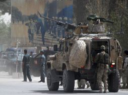 Guardias de seguridad afganos inspeccionan el lugar de un ataque contra un vehículo militar. EFE  /