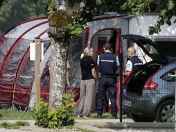 Agentes investigadores permanecen en las proximidades de la escena donde fueron encontradas las víctimas. AFP  /