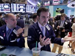 Especialistas trabajan en el puesto de Pandora que comercia en un piso de la Bolsa de Nueva York este viernes. AP  /