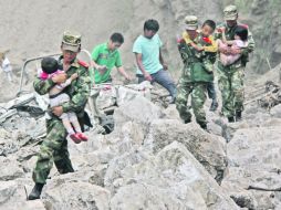 Soldados cargan a niños de Zhaotong, provincia de Yunnan, donde dos sismos causaron cientos de derrumbes de viviendas. REUTERS  /