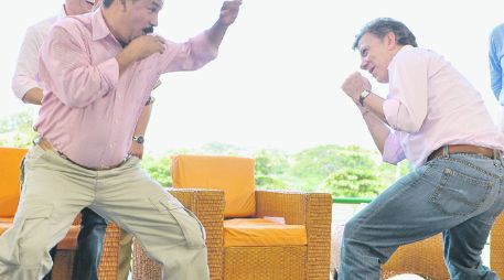 Juan Manuel Santos prueba en broma algunos golpes de boxeo con el ex campeón mundial del peso gallo, Miguel ''Happy'' Lora. EFE  /