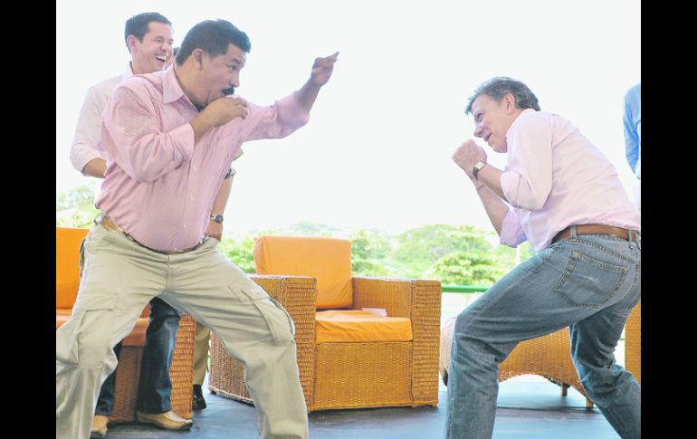Juan Manuel Santos prueba en broma algunos golpes de boxeo con el ex campeón mundial del peso gallo, Miguel ''Happy'' Lora. EFE  /