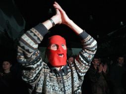 Un asistente al festival por la libertad de las Pussy Riot cubre su cara con una de las 'máscaras' que identifican a la banda. AFP  /
