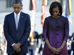 Barack Obama y su esposa Michelle guardan un minuto de silencio por los fallecidos en el atentado de 2001. AP  /