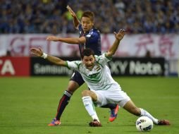 El japonés Hiroshi Kiyotake (atrás) lucha por el balón con el iraquí Salim Waleed durante el partido clasificatorio mundialista. EFE  /