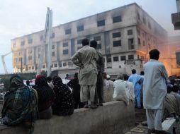 Residentes observan los operativos de rescate en las dos fábricas incendidadas en la ciudad de Karachi. AFP  /