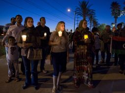 Estadounidenses sostienen velas y realizan una procesión para recordar a los fallecidos en el ataque. XINHUA  /