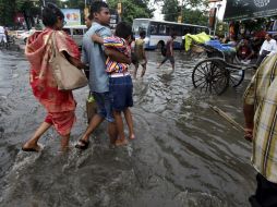 Un grupo de personas cruza una calle inundada en Calcuta. EFE  /