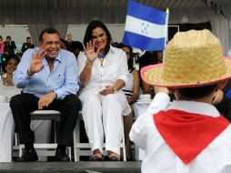 El presidente hondureño saluda a un niño durante los festejos de independencia. AFP  /