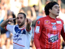 Lizandro López Festeja ante Ochoa el segundo gol del Lyon. AFP  /